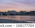 Blackfriars Bridge, London, UK, at sunset on a summer's evening. The sky is pink and orange, and it is reflecting in the River Thames 108177769