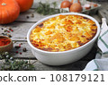 French cuisine. Vegetable pumpkin clafoutis in ceramic bakeware, smoked paprika dressing 108179121