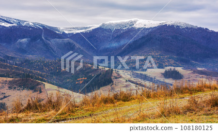 countryside landscape with snow capped tops in the distance. gloomy scenery of borzhava ridge with overcast sky in late autumn countryside landscape with snow capped tops in the distance. gloomy scenery of borzhava ridge with overcast sky in late autumn 108180125