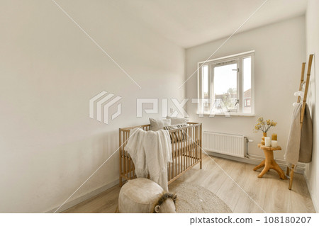 a baby's room with a cribt in the corner and a teddy bear next to the cribt 108180207