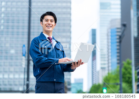 A middle-aged businessman wearing work clothes working in an office area using a computer A middle-aged businessman wearing work clothes working in an office area using a computer 108180545
