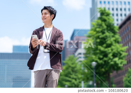 使用智慧型手機在辦公區域工作的中年男性工程師 108180620