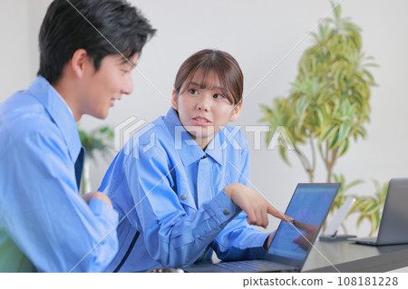 Men and women in work clothes having a meeting while looking at a PC 1 108181228