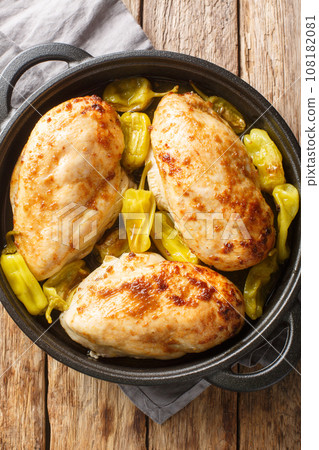 Oven Baked Mississippi Chicken with ranch seasoning, dried au jus gravy mix and pepperoncini peppers closeup on the pan. Vertical top view 108182081