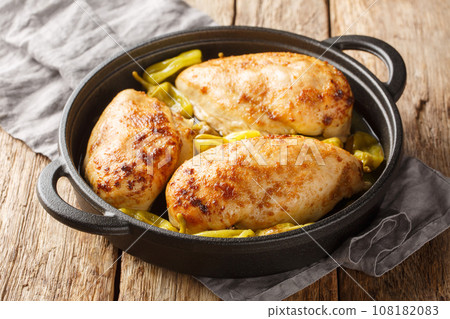 Crock Pot Mississippi Chicken is made with chicken breasts, au jus gravy, ranch seasoning, real butter and pepperoncini peppers closeup on the pan. Horizontal Crock Pot Mississippi Chicken is made with chicken breasts, au jus gravy, ranch seasoning, real butter and pepperoncini peppers closeup on the pan. Horizontal 108182083