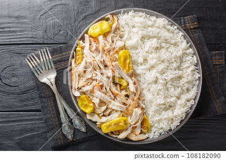 Shredded baked chicken fillet with peperoncini peppers served with rice close-up in a plate. horizontal top view Shredded baked chicken fillet with peperoncini peppers served with rice close-up in a plate. horizontal top view 108182090