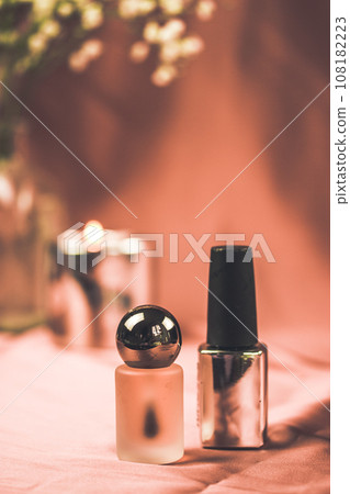 Two tubes with decorative cosmetic, perfume water bottle, nail polish on pink coral background. Cosmetic table in female room. Vertical banner with no brand cosmetics bottles Beauty, self care concept 108182223