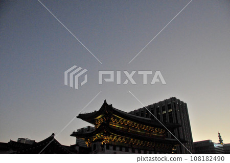 Light up of Gyeongbokgung Palace entrance gate in the evening among modern apartment buildings. Light up of Gyeongbokgung Palace entrance gate in the evening among modern apartment buildings. 108182490