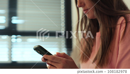 Hand of woman using texting mobile phone or chat. Close up of woman hand. Sunlight. 108182978