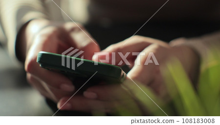 Woman hand typing or chat on smartphone. Browsing news or messages in social networks. Modern wireless tech usage concept. Close up of girl hand. 108183008