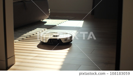 Vacuum Robot cleaning at home. Robot vacuum cleaner in the modern home. Smart cleaning technology. Vacuum Robot cleaning at home. Robot vacuum cleaner in the modern home. Smart cleaning technology. 108183059