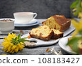 Summer dessert. Raisin cake, cup of tea and bouquet of forsythia 108183427