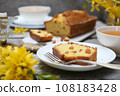 Summer dessert. Raisin cake, cups of tea and bouquet of forsythia 108183428