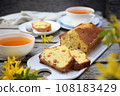 Summer dessert. Raisin cake, cups of tea and bouquet of forsythia 108183429