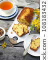 Summer dessert. Raisin cake, cup of tea and bouquet of forsythia 108183432