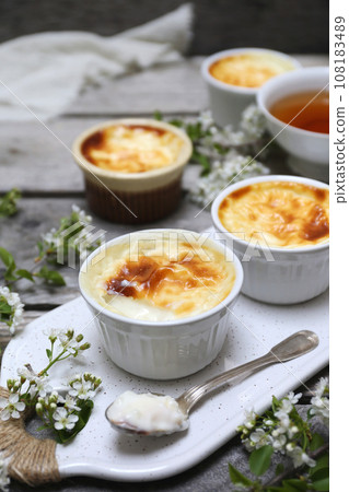 Sutlac. Traditional Turkish rice dessert. Rice pudding, four servings and tea and spring white flowers Sutlac. Traditional Turkish rice dessert. Rice pudding, four servings and tea and spring white flowers 108183489