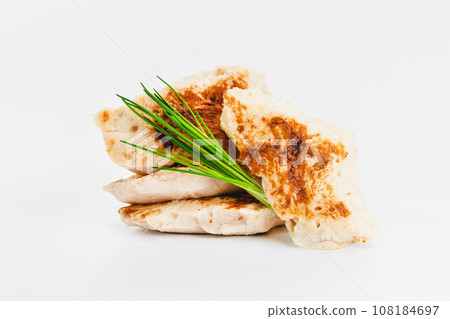 Chicken fillets fried until half cooked, semi-finished product with fresh herbs on a white background. Fast food. Quick cooking at home. Copy space.Fast cooking.Fast homemade food. 108184697