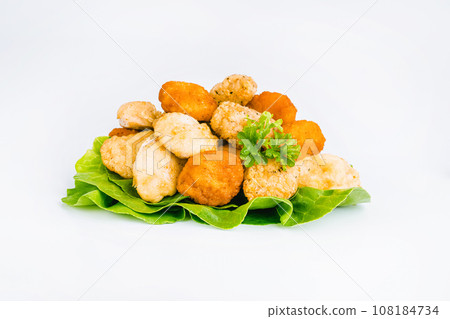 Breaded Chicken Inner Fillet with green lettuce leaves on a White Background,Chicken Breaded Raw Meat,Fillet.Breaded chicken nuggets. Fast homemade food at home.Chicken breaded schnitzels.Fast cooking 108184734