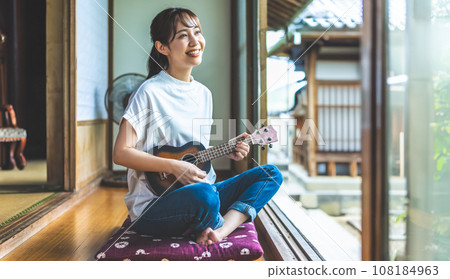 A woman playing the ukulele in a Japanese-style room 108184963
