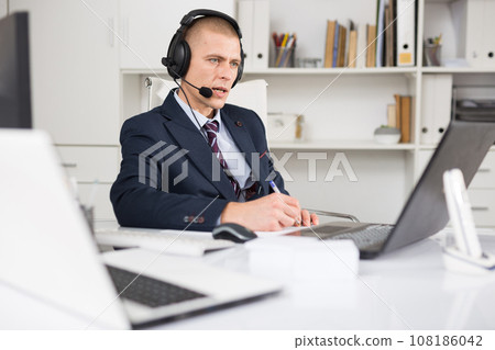 Head of the company conducts online negotiations with business partners in headphones Head of the company conducts online negotiations with business partners in headphones 108186042