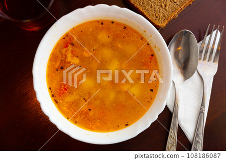 Thick delicious chicken broth with vegetables close up 108186087