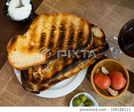 Toasted bread, tomatoes, garlic, pickled olives and aioli for Pan con tomate 108186111