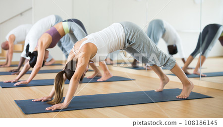 Young woman practicing yoga at group class 108186145