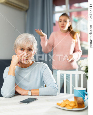 Offended elderly woman listening her daughter swearing Offended elderly woman listening her daughter swearing 108186413