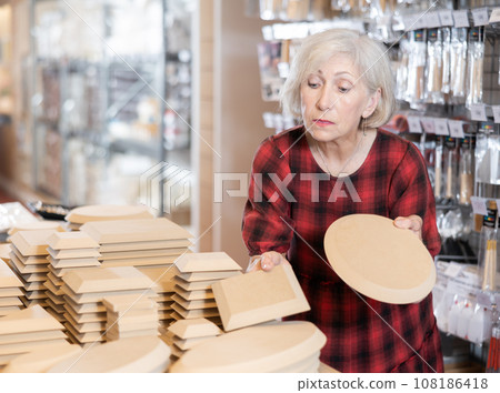Elderly woman chooses blanks for making pottery 108186418