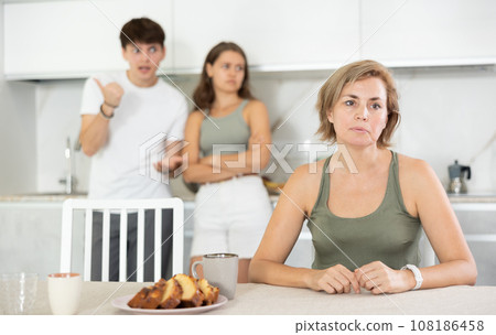 Adult children guy and girl are fighting with elderly woman mother. 108186458