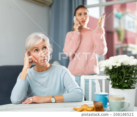 Senior woman listening her daughter aggressively talking on phone 108186521