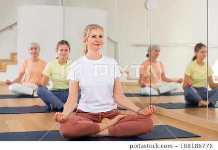 Woman practice yoga lotus pose Woman practice yoga lotus pose 108186776