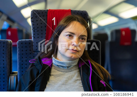 Relaxed contemplative brunette woman travelling by train Relaxed contemplative brunette woman travelling by train 108186941