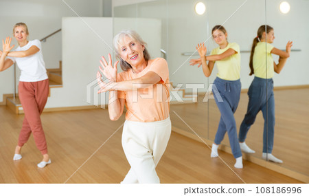 Senior woman performing dance with her relatives 108186996