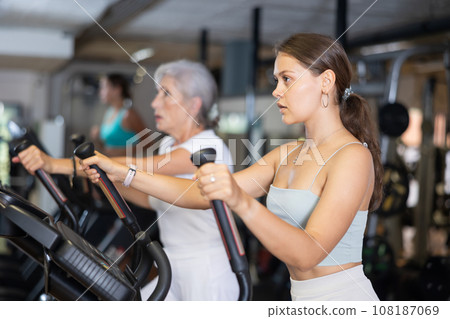 Young woman working out on elliptical machine Young woman working out on elliptical machine 108187069
