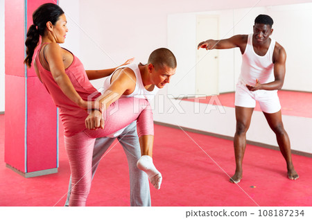 Asian woman under the guidance of trainer makes painful grip in self defense training 108187234