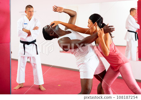 Woman painful eye blow to african american man in self defense training 108187254