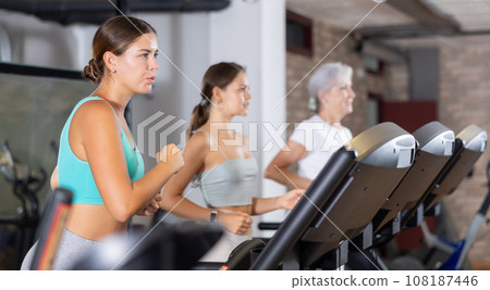 Young woman exercising on treadmill in gym Young woman exercising on treadmill in gym 108187446