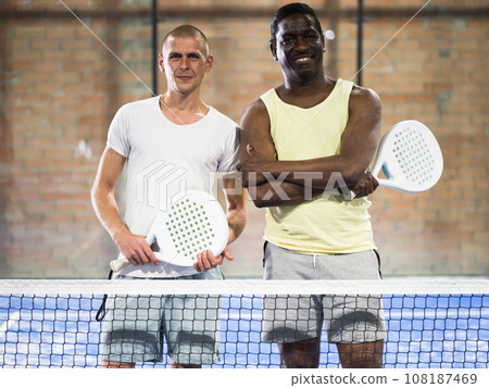 Portrait of two smiling male sportsman's posing on padel court Portrait of two smiling male sportsman's posing on padel court 108187469