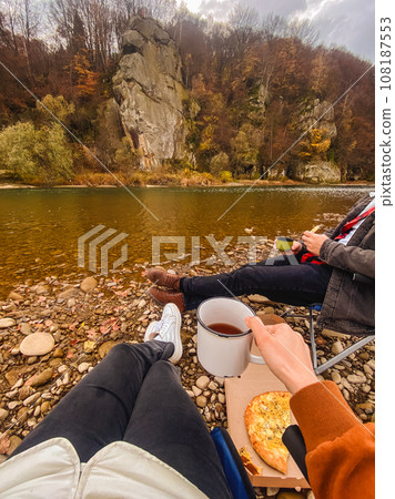 couple resting at autumn river side drinking warm tea couple resting at autumn river side drinking warm tea 108187553