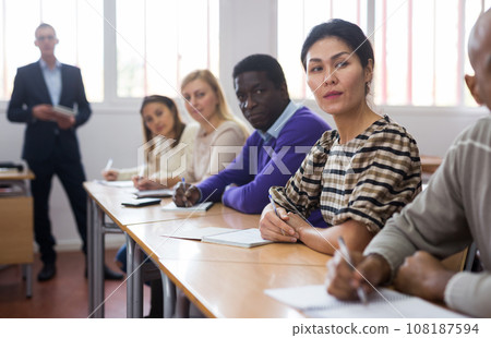 Asian woman listening to lecture in classroom with group 108187594