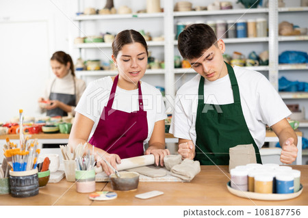 Young woman and young man making pottery 108187756