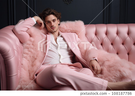 fashionable stylish man in a pink elegant suit on a pink fur chair. fashionable stylish man in a pink elegant suit on a pink fur chair. 108187786