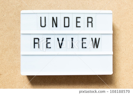 Lightbox with word under review on wood background 108188570