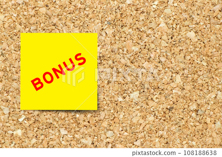 Yellow note paper with word bonus on cork board background with copy space Yellow note paper with word bonus on cork board background with copy space 108188638