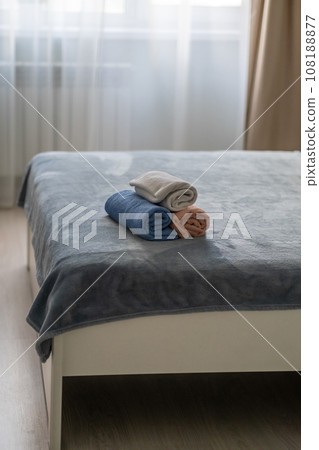 Close-up of three fresh clean folded towels on a hotel bed. Room for tourists and for relaxation. Clean room 108188877