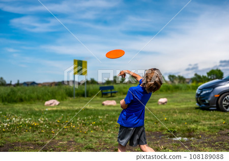 Caucasian child playing disc golf and making the first toss 108189088