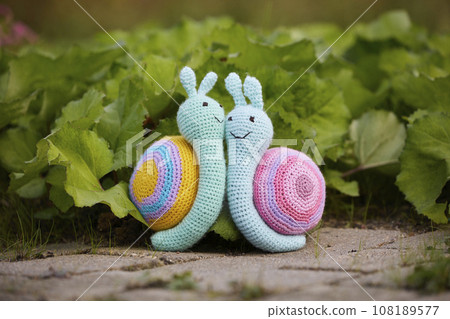 Cute knitted toy snails kissing like a married couple 108189577