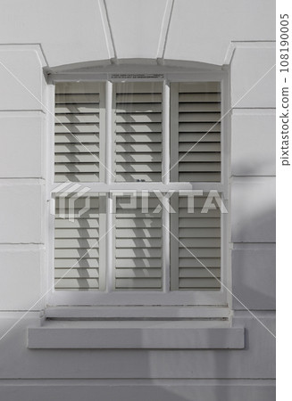 UK house exterior with wooden casement window and white bricks wall. 108190005