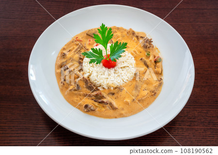 Classic chicken beef stroganoff with rice, herbs and cherry tomato with parsley leaves Classic chicken beef stroganoff with rice, herbs and cherry tomato with parsley leaves 108190562